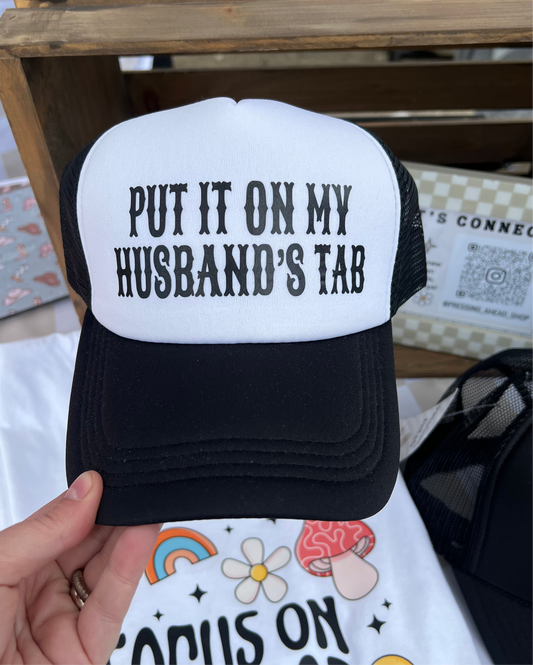 Put It On My Husband’s Tab Trucker Hat